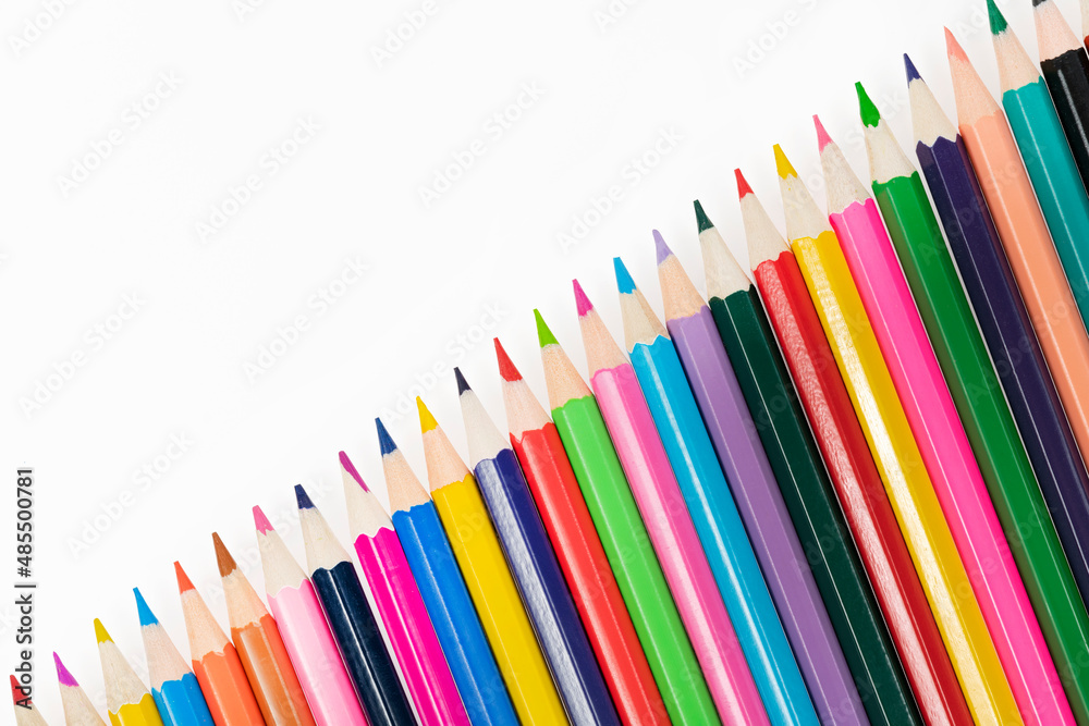 Fototapeta premium Wooden colored pencils isolated on a white background. A line of multicolored pencils in a large plan