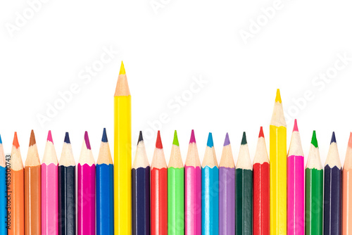 Wooden colored pencils isolated on a white background. A line of multicolored pencils in a large plan