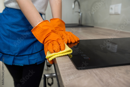 strong female hands in work gloves wipe the kitchen surface from dirt