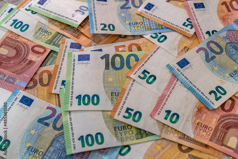 Beautiful multicolored new euro banknotes scattered in a pile on a spacious table. Beautiful multicolored new euro banknotes scattered in a pile on a spacious table.