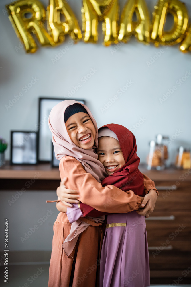 two little young girl with headscarf embracing each other