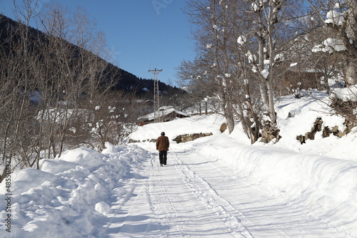 old man walking on snow covered road.Artvin. Turkey