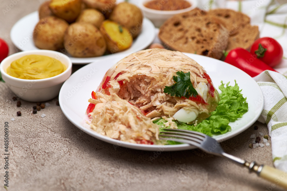 Delicious chicken aspic on a plate on concrete table Delicious chicken aspic on a plate on concrete table