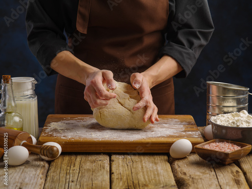 The process of preparing dough products by a professional chef. Cooking bread, pizza, pasta, pies, ravioli. Large group of objects. Dark background. Close-up.