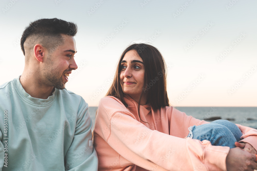 Young caucasian couple chatting at the sea side. Young caucasian couple chatting at the sea side.