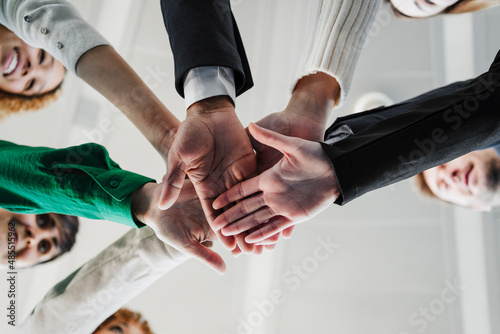 Business colleagues stacking hands in office