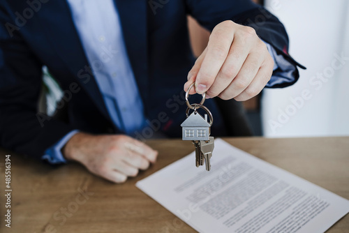 Businessman holding bunch of house keys in office