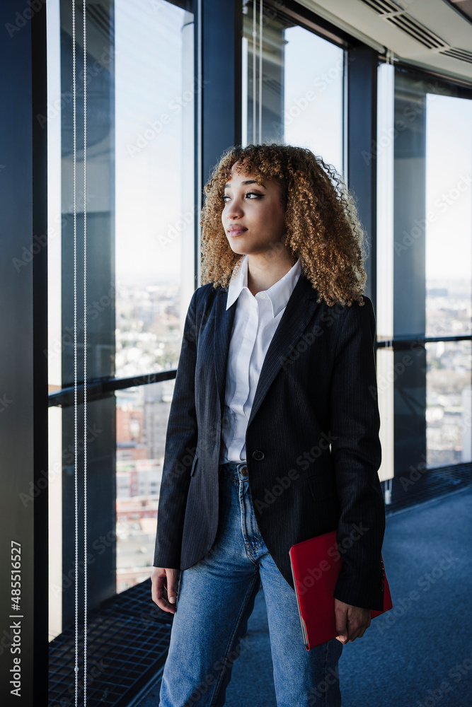 Thoughtful businesswoman with tablet PC standing in office Thoughtful businesswoman with tablet PC standing in office