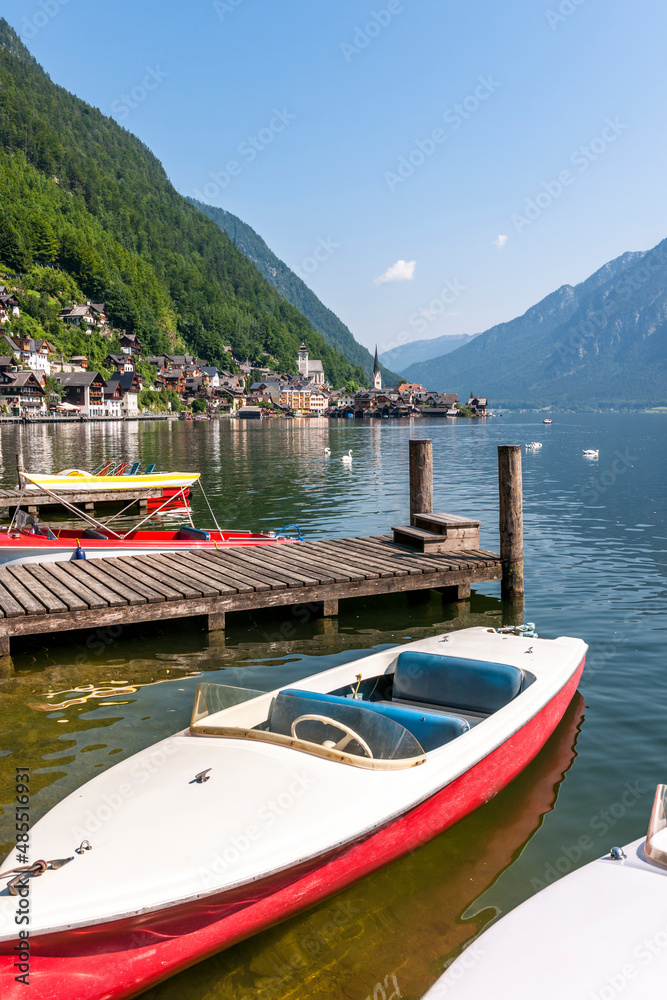Austria, Upper Austria, Hallstatt, boat moored on shore of Lake Hallstatt with town in background Austria, Upper Austria, Hallstatt, boat moored on shore of Lake Hallstatt with town in background