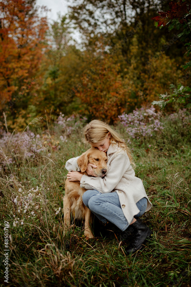 Blond girl hugging Yellow Labrador Retriever in garden Blond girl hugging Yellow Labrador Retriever in garden