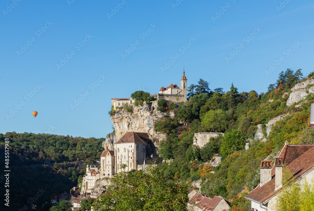 France, Lot, Rocamadour, View of cliffside town with hot air balloon in background France, Lot, Rocamadour, View of cliffside town with hot air balloon in background