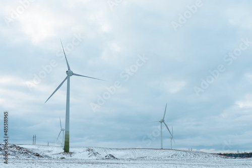 Winter shot a few windmill and blue cloudy sky wind generators in winter.