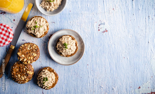 Homemade vegan tuna spread. Homemade vegan tuna spread served on whole grain bread, with a coffee and orange juice on the side. On a white table top.