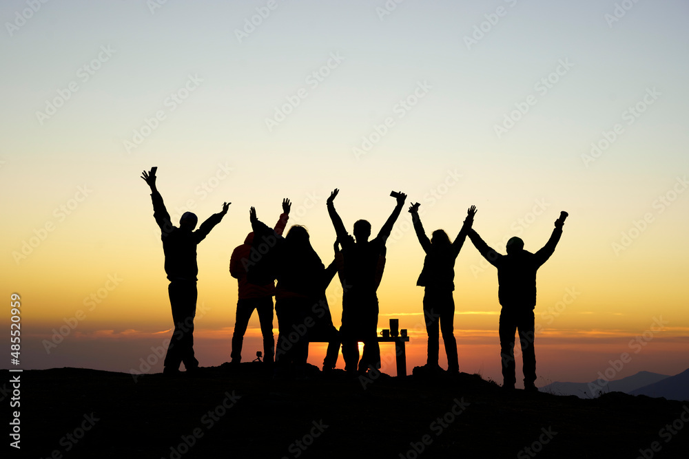 Silhouette friends with arms raised at sunset, Sochi, Krasnaya Polyana, Russia Silhouette friends with arms raised at sunset, Sochi, Krasnaya Polyana, Russia