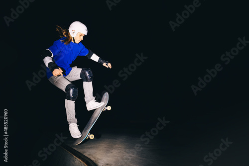 Skateboarder practicing on skateboard at night photo