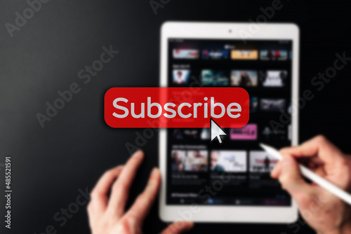 Subscription plan. Red online video subscribe button. Internet service on laptop digital tablet blured technology background. Visual contents concept. Social networking service.