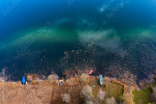 Drone view of rowboats left on shore of Irrsee lake in autumn photo