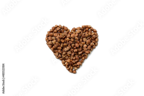 Buckwheat grains stacked in the shape of a heart on a white isolated background, top view.