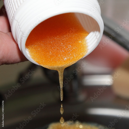 Pouring water softening ion exchange resin from the cartridge closeup for recovery photo