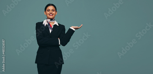 Stewardess holding out her hand in a studio photo