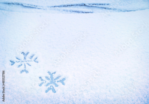 Two snowflakes hand drawing (painted) on snow under windshield wiper of car. Transportf, winter, weather, snowfall concept. Copy space. Empty place. Selective focus.