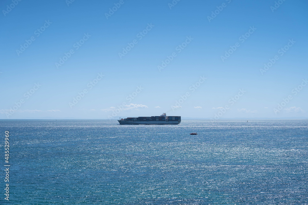 Ship Crossing the Horizon on a Sunny Day with Calm Waters 