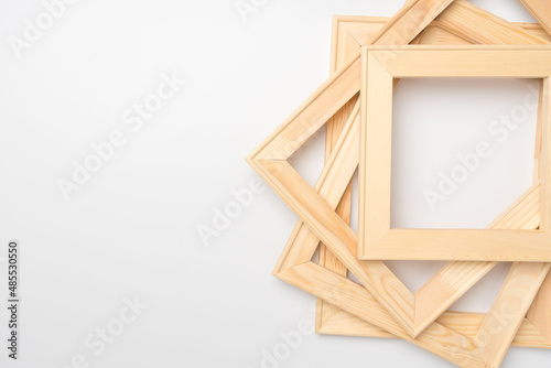 A stack of wooden stretchers for canvas stretching on a white background, copy space