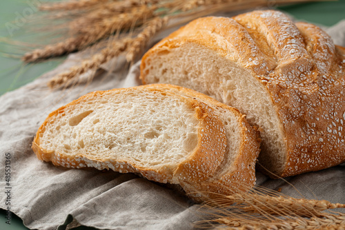 Freshly baked sliced loaf of creamy bread on napkin 