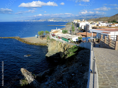 Stone paved cliff walking path with beautiful Mediterranean view and Torrenueva Costa town. photo