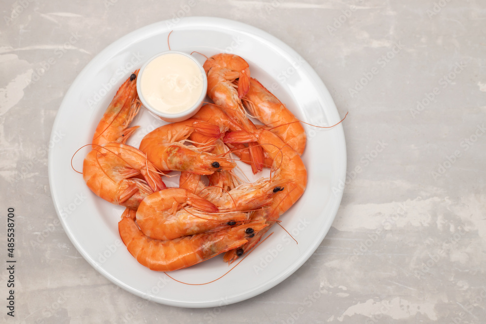 Boiled fresh shrimps with sauce in small bowl on white plate on ceramic Boiled fresh shrimps with sauce in small bowl on white plate on ceramic