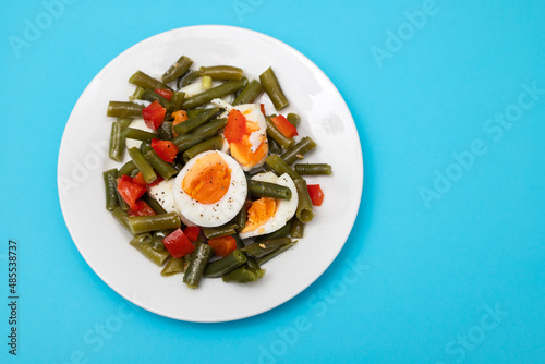 salad green beans, pepper and boiled eggs on plate