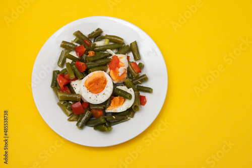 healthy salad green beans, pepper and boiled eggs on plate