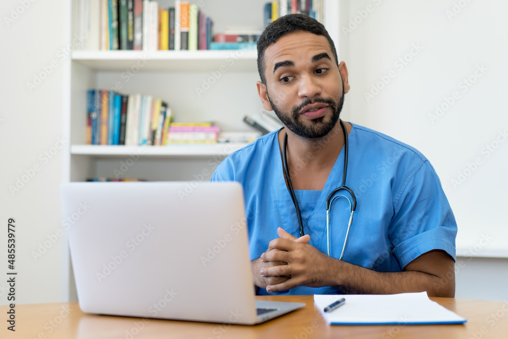 Handsome latin american male nurse talking with patient at computer Handsome latin american male nurse talking with patient at computer