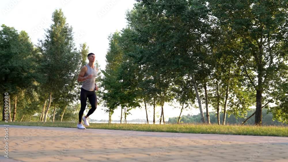outdoor training of sporty man running in park, jogger outdoor training of sporty man running in park, jogger