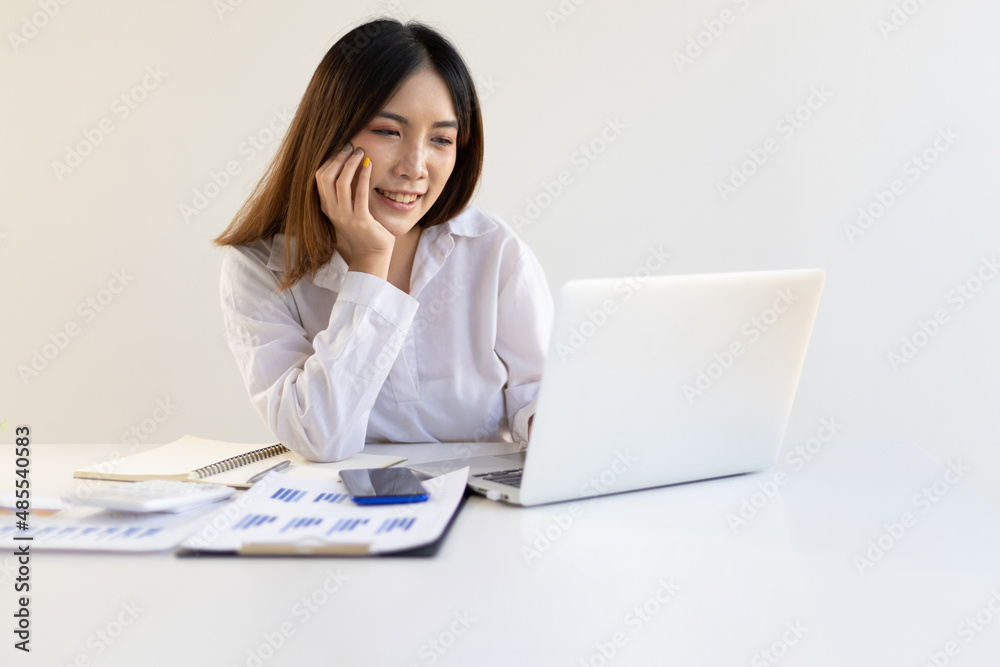 Happy woman working on laptop and paperwork. Happy woman working on laptop and paperwork.