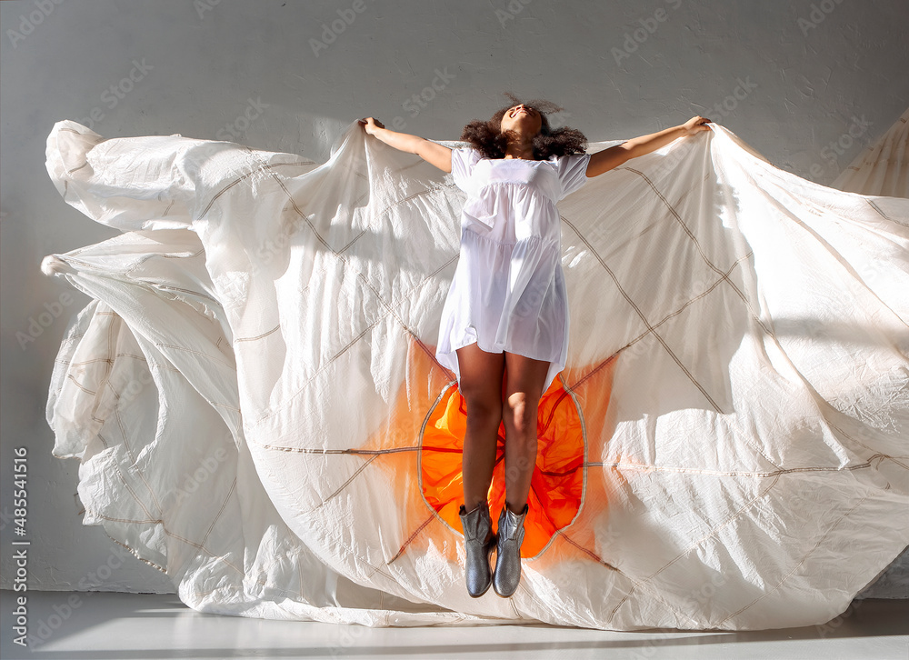 Jump and fly. Young carefree african american woman jumping in air with ...