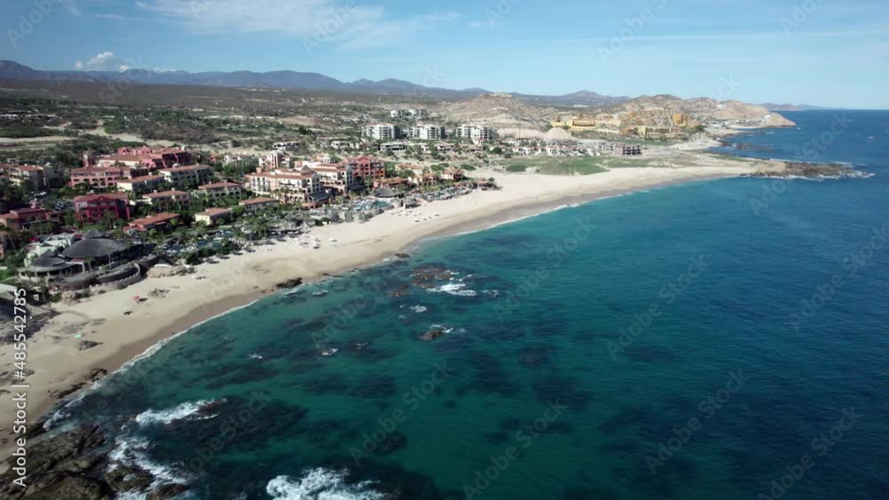 Resorts and hotels along a pristine beach in a tropical paradise vacation destination - aerial flyover Resorts and hotels along a pristine beach in a tropical paradise vacation destination - aerial flyover