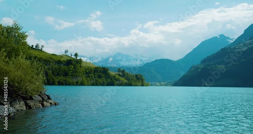 Wallpaper Mural Picturesque view of lake in Brienz Switzerland at noon as water ripples calming move towards shore with cloudy mountains in the distance in Europe, wide view Torontodigital.ca