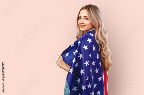 Portrait of a young woman holding USA flag isolated on color background