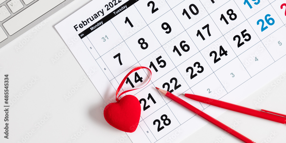 Valentine's Day background. Office table. Date February 14 on calendar 2022, Valentine's Day red heart circled. Flat lay, top view, copy space Valentine's Day background. Office table. Date February 14 on calendar 2022, Valentine's Day red heart circled. Flat lay, top view, copy space