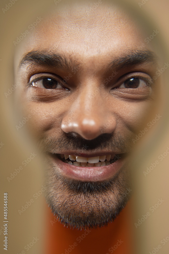Close-up portrait of a human face looking through keyhole