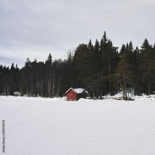 red boathouse by Vesle Vålsjøen Lake up in the Totenåsen Hills, Norway, in winter