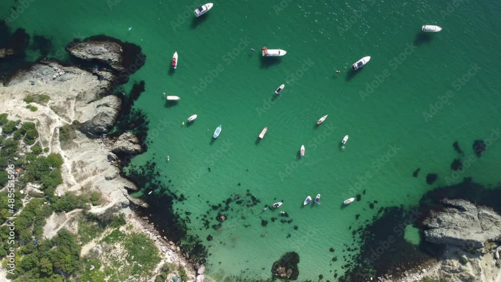 Aerial panoramic view of seascape with crystal clear azure sea and rocky shores. Yachts in a beautiful lagoon on backdrop of rocks. The concept of an ideal destination for summer travel and vacation. Aerial panoramic view of seascape with crystal clear azure sea and rocky shores. Yachts in a beautiful lagoon on backdrop of rocks. The concept of an ideal destination for summer travel and vacation.