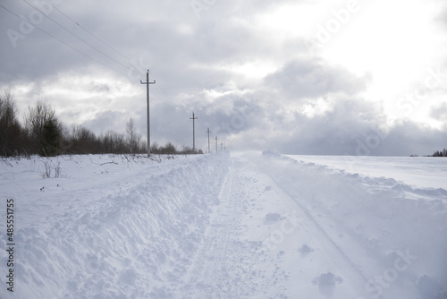 A deserted country road through snow-covered fields. © FO_DE