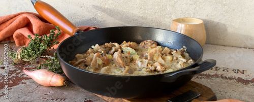 pan with chicken fricassee with oyster mushrooms on the table photo