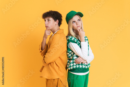 White puzzled girl and boy holding their chins while looking upward