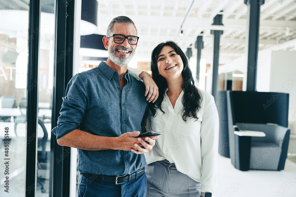 Businesspeople smiling at the camera in an office Businesspeople smiling at the camera in an office