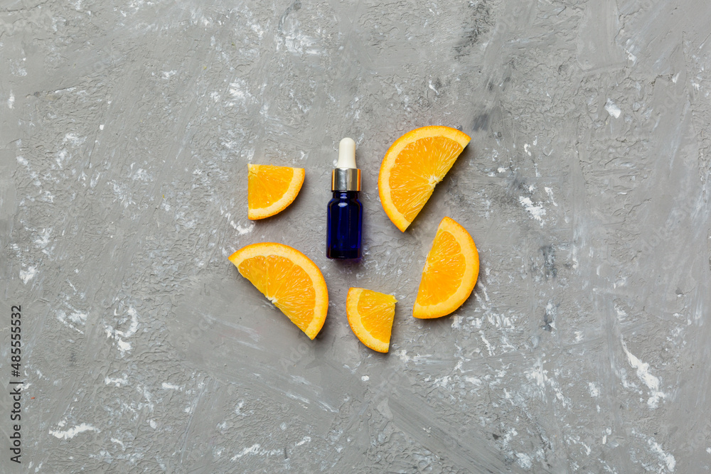 Obraz premium Bottles with orange fruit essential oil on wooden background. alternative medicine top view with copy space