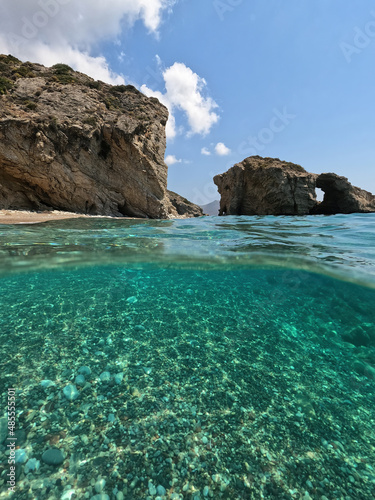 Underwater split photo of natural exotic island rocky bay with turquoise crystal clear sea and small caves