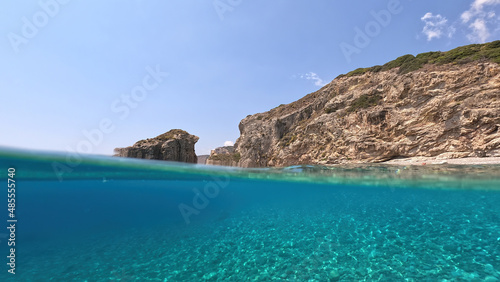 Underwater split photo of natural exotic island rocky bay with turquoise crystal clear sea and small caves